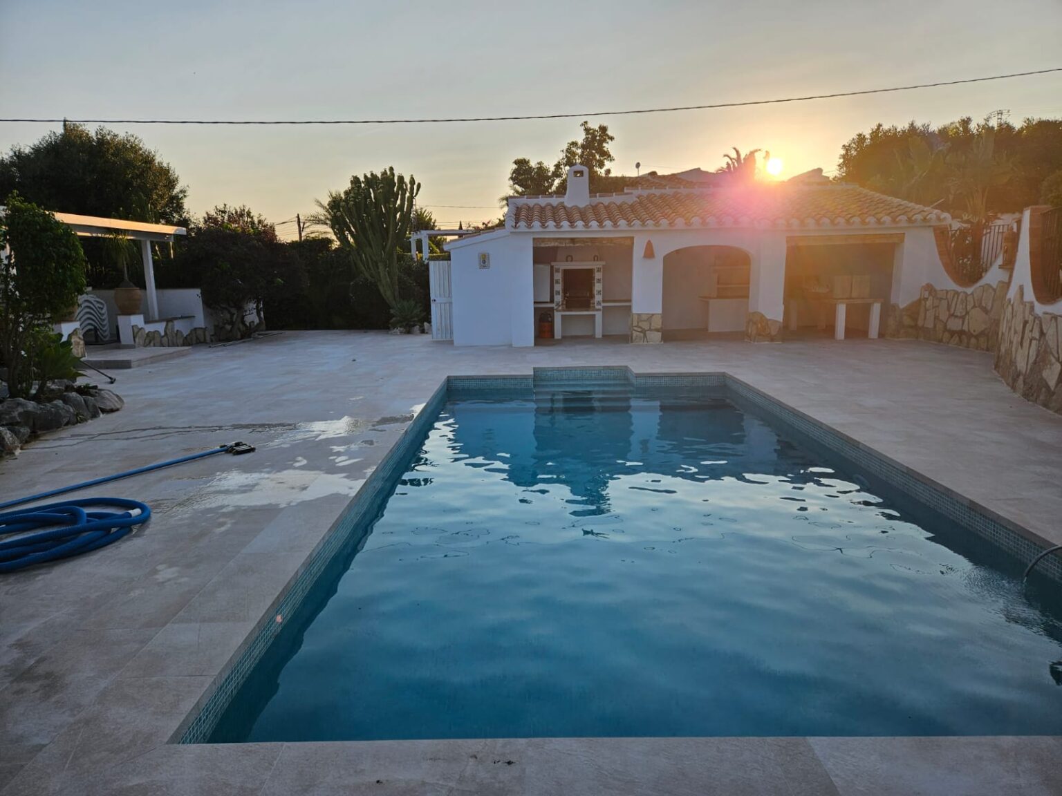 Piscina iluminada al atardecer en vivienda reformada.