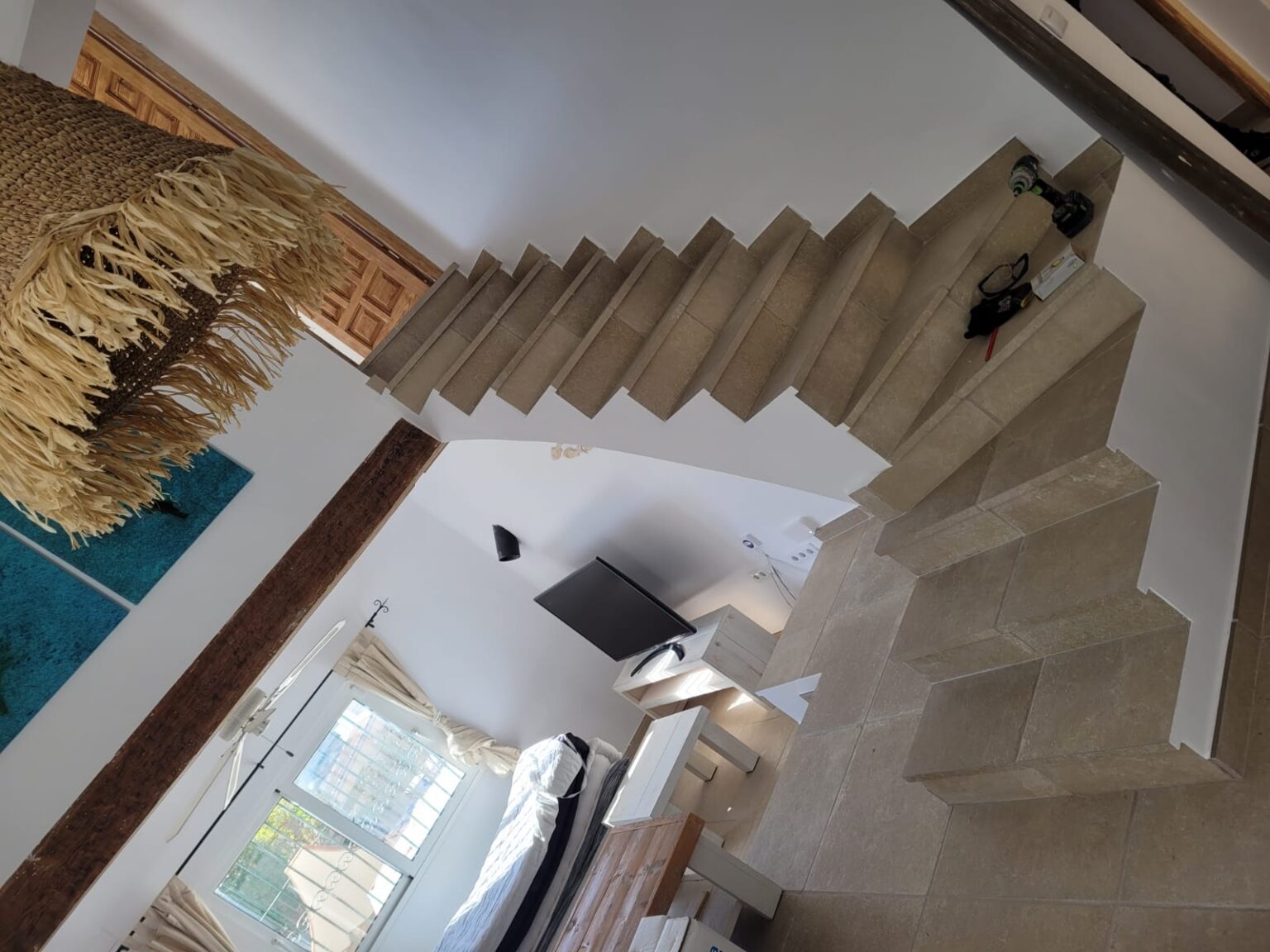 Salón reformado con escalera de obra y diseño moderno.