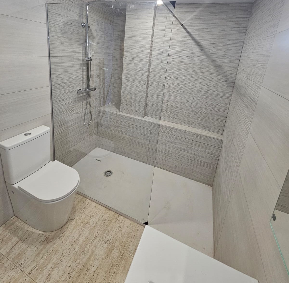 Lavadero y baño pequeño reformado con mobiliario integrado.