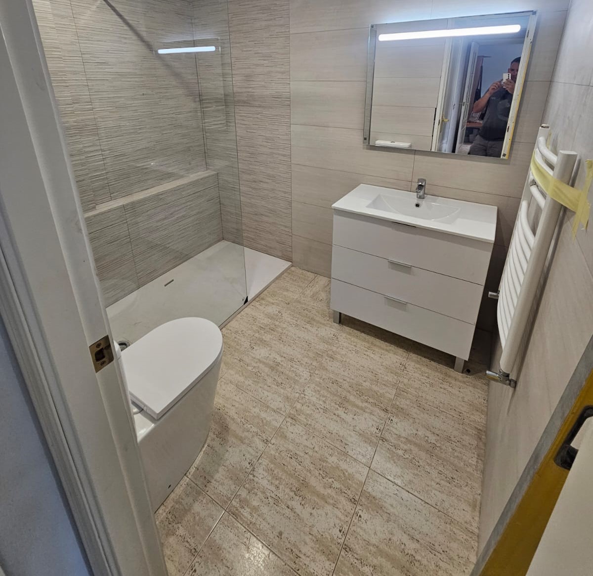 Baño reformado con ducha de cristal y diseño contemporáneo.