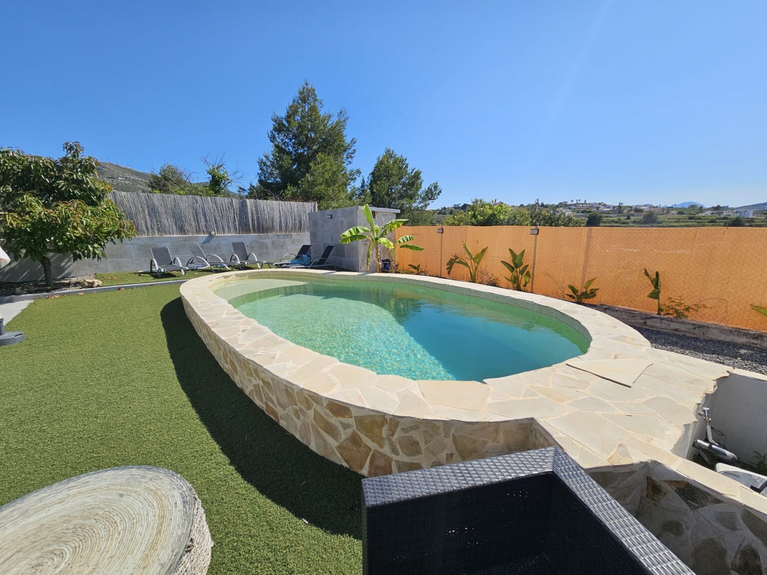 Piscina circular construida en jardín con césped.